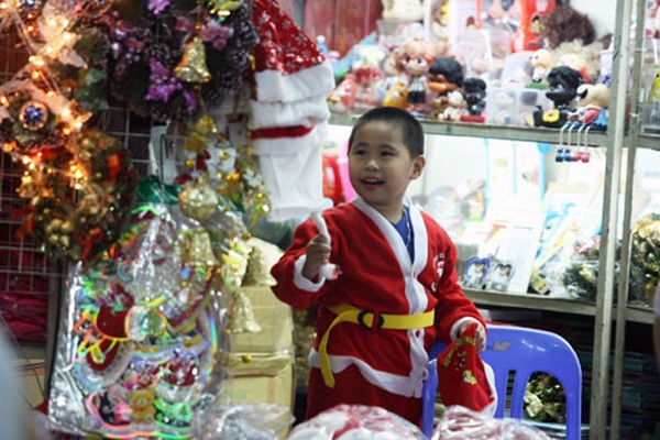 Nhiều em nhỏ đi chọn đồ chơi Giáng sinh khoác trên mình bộ quần áo của ông già Noel. Mặc dù chưa thực sự đông khách, nhưng đến phố Hàng Mã thời điểm này ai cũng có thể cảm nhận được hơi thở Giáng sinh đang rất gần.